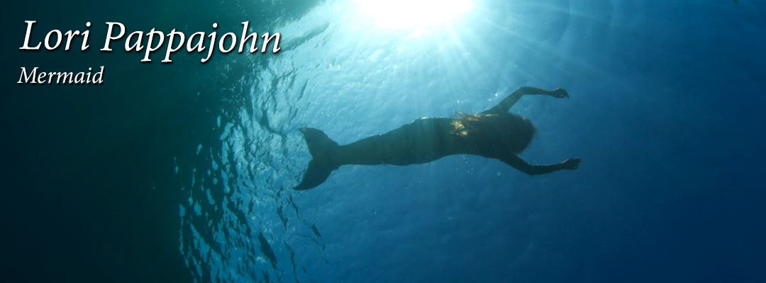 Lori Pappajohn Professional Mermaid swimming underwater photo with streaming sunlight.